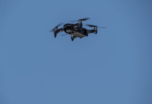 drone moving the blades flying through the blue sky photo
