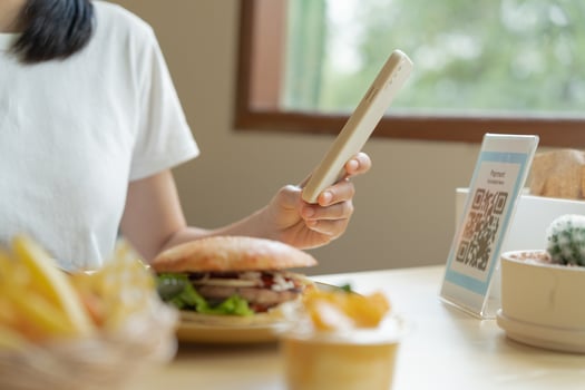 Woman use smartphone to scan QR code for order menu in cafe restaurant with a digital delivery. Choose menu and order accumulate discount. E wallet, technology, pay online, credit card, bank app. photo