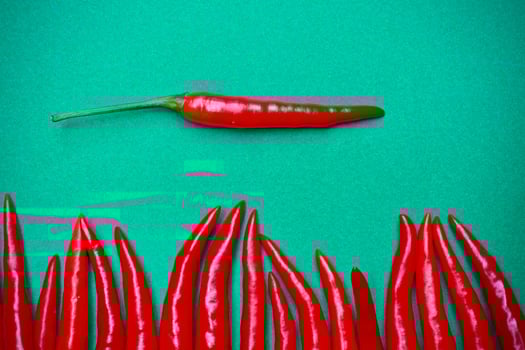 Spicy red chili on green background photo