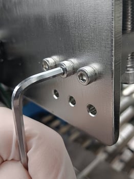 Hex wrench is unscrewing a nut made of stainless steel photo