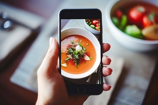 A woman takes pictures of food on her phone. photo