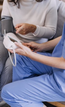 Homecare nursing service and elderly people cardiology healthcare. Close up of young hispanic female doctor nurse check mature caucasian man patient heartbeat using stethoscope during visit photo