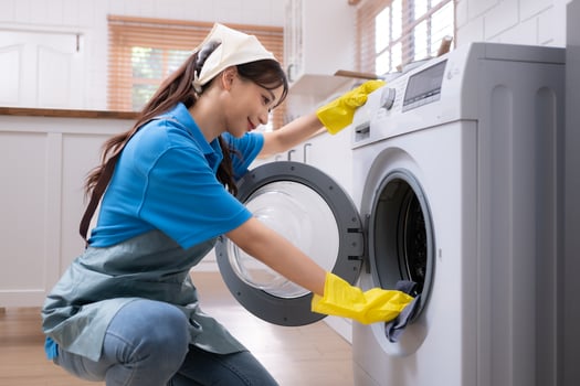 Asian young woman cleaning the washing machine in the kitchen. housework concept photo