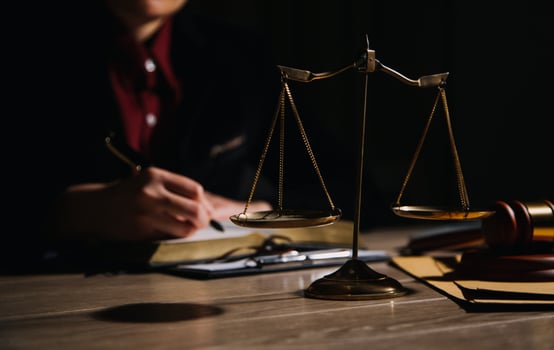 Justice and law concept.Male judge in a courtroom with the gavel, working with, computer and docking keyboard, eyeglasses, on table in morning light photo