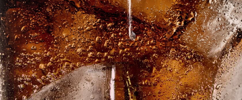 Cola soda and ice splashing fizzing or floating up to top of surface photo