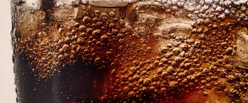 Cola soda and ice splashing fizzing or floating up to top of surface photo