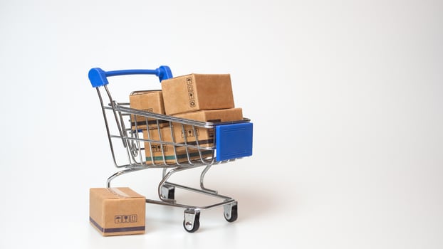 Shopping concept. Paper boxes in blue shopping cart on white background. online shopping consumers can shop from home and delivery service. with copy space photo