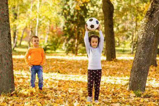 Little girl with ball in the autumn park photo