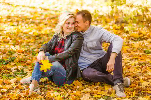 Young woman and man walking in autumn city park photo