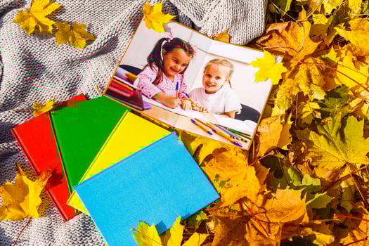 little girls in a photo book lie in autumn leaves
