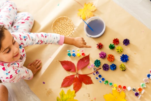 Cute little girl coloring a natural cone fir to create a flower, set of brushes, paints, natural autumn materials, create fun and easy with children, diy for kindergarten photo