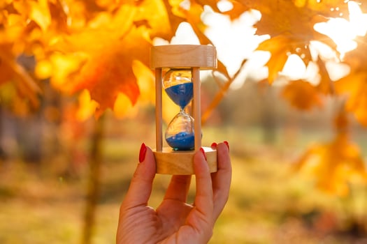 Autumn time theme, Sandglass on fallen leaves in various colors with copy space. photo