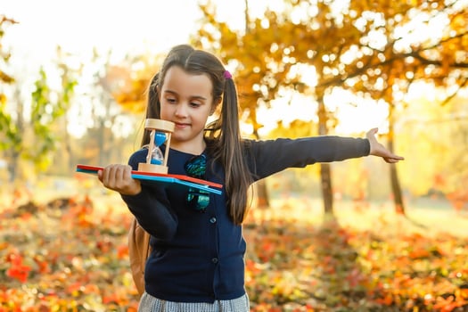 Little schoolgirl near the school. preschool child with a backpack on his first day at school or kindergarten. Back to school. Child education. autumn photo