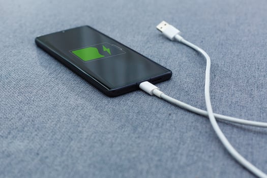 Mobile smart phones charging on gray background photo