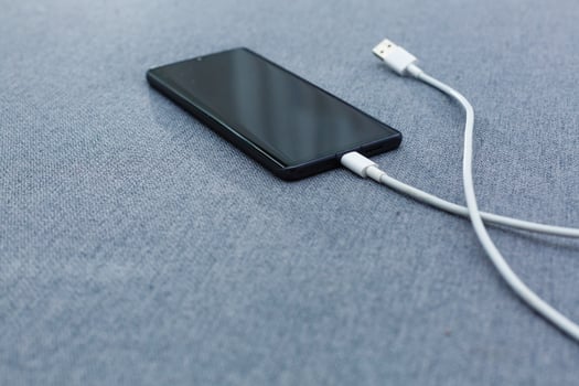 Mobile smart phones charging on gray background photo