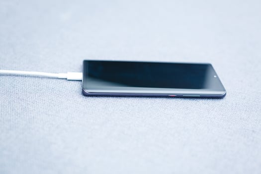 Mobile smart phones charging on gray background photo