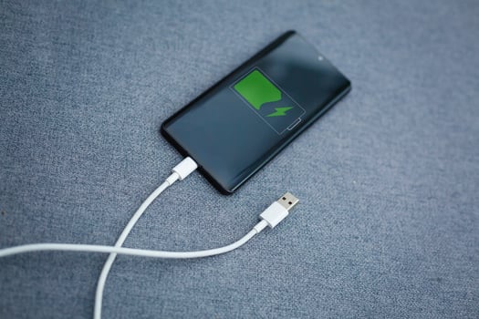Mobile smart phones charging on gray background photo