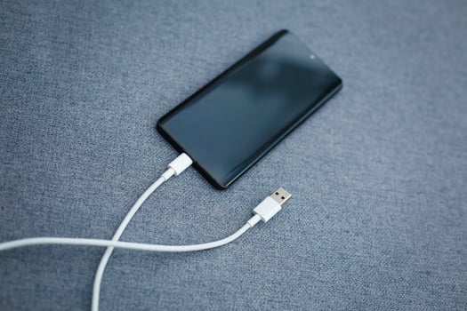 Mobile smart phones charging on gray background photo