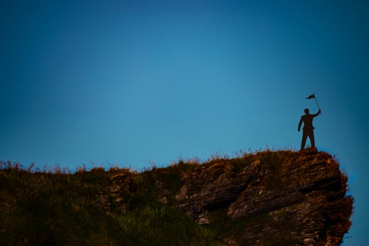 silhouette of man on mountain top over sky and sun light background,business, success, leadership, achievement and people concept photo