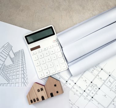 real estate and property, architecture, building, construction concept - Tiny house model on an architect's desk photo