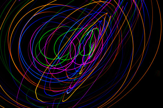 Multi color light painting photography, swirl and curve of blue, green and red light against a black background. photo