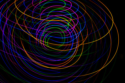 Multi color light painting photography, swirl and curve of blue, green and red light against a black background. photo