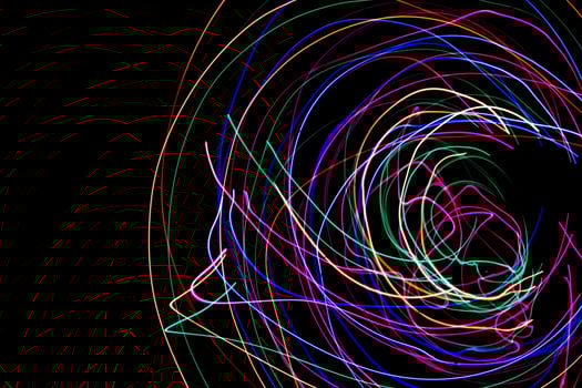 Multi color light painting photography, swirl and curve of blue, green and red light against a black background. photo