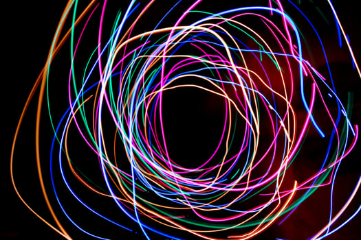 Multi color light painting photography, swirl and curve of blue, green and red light against a black background. photo
