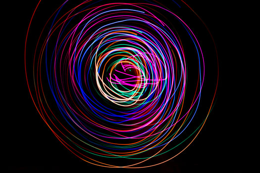 Multi color light painting photography, swirl and curve of blue, green and red light against a black background. photo