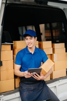 Portrait of courier delivery Asian man searching the address on digital tablet. Delivery service, delivery home and shipping concept. photo