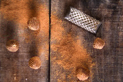 a grater with nuts on a wooden surface photo
