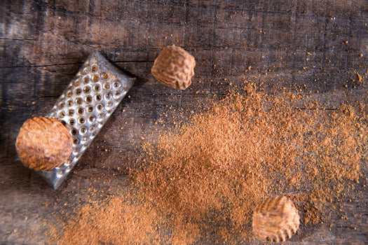 a grater with nuts on a wooden surface photo