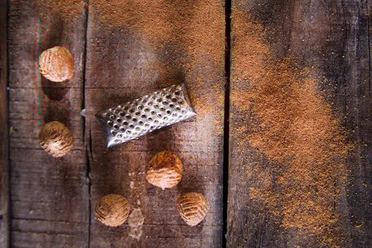 a grater with nuts on a wooden surface photo