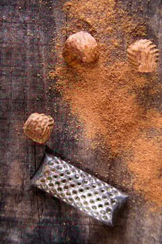 a grater with nuts on a wooden surface photo