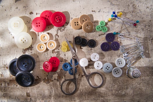 sewing supplies and buttons arranged on a white surface photo