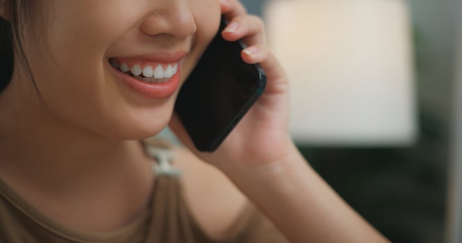 Asian happy cheerful young woman talking on the phone photo