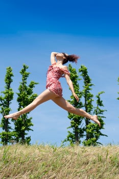 Girl jumping in nature in spring season photo