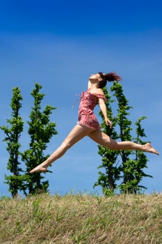 Girl jumping in nature in spring season photo