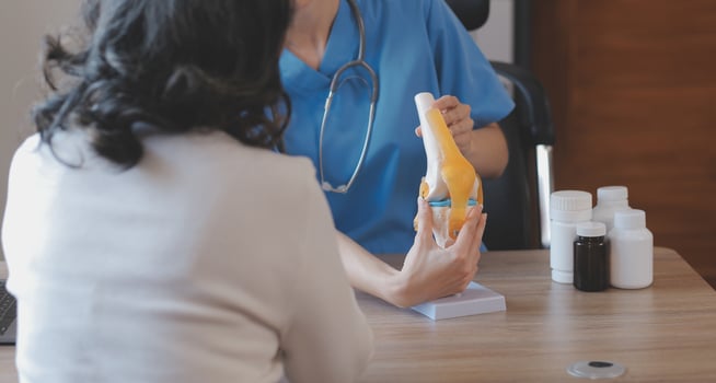 Doctor and patient talking while sitting at the desk in hospital office, closeup of human hands. Medicine and health care concept photo
