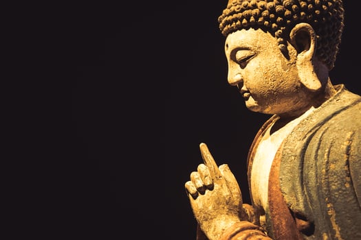 Buddha Statue - Concept of Zen, Spirituality, Peace. Copy space on Black Background photo