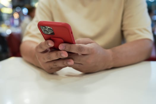 Relaxed young asian man using smart phone  spending time checking news social media. photo