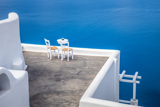 Two chairs on the terrace with sea views. Santorini island, Greece. Travel and vacation background. Best in travel landscape for romantic couple or honeymoon destination. Fantastic location and view photo