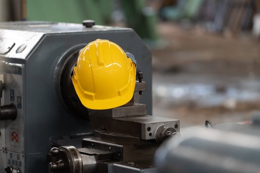 Yellow helmet with machinery, the background is factory photo