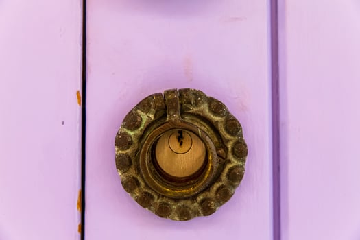 Old and rusty lock over a pink wooden door photo