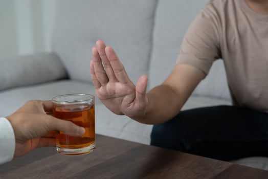 man refuses say no and avoid to drink an alcohol whiskey , stopping hand sign male, alcoholism treatment, alcohol addiction, quit booze, Stop Drinking Alcohol. Refuse Glass liquor, unhealthy, reject photo