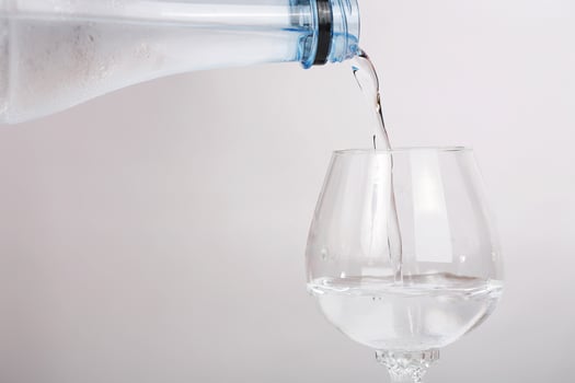 Pour mineral water in the bottle on clean grass. photo