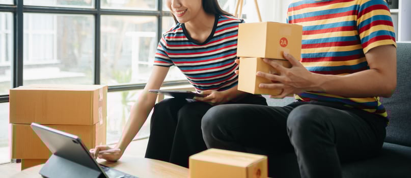 young Asian man and woman at office of their business online shopping.In home office photo