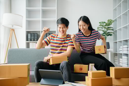 young Asian man and woman at office of their business online shopping.In home office photo