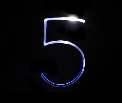 Five blue light digit hand writing over black background. photo