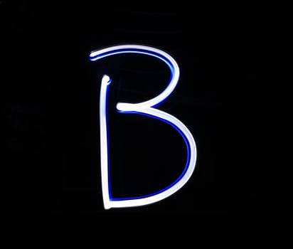 B Baker alphabet hand writing blue light  over black background. photo
